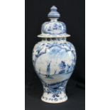 A late 18th century blue and white Delft vase and cover, painted with flowers, sailing boats and