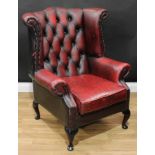 A Chesterfield style wingback armchair, deep-button upholstery, scroll arms, squab cushion, cabriole