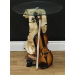 Interior Design - a novelty ocassional table, circular glass top, the base as a musical trophy