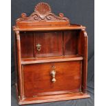 An early 20th century mahogany desk top cabinet, shaped cresting above an open niche and fall front,