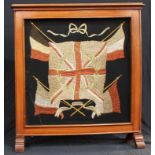 An early 20th century mahogany and needlework fire screen, embroidered flags on black panel, 66cm