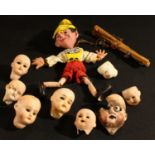 A collection of 19th century bisque dolls heads; a Pelham Puppet, Pinocchio