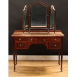 An Edwardian mahogany bow front dressing table, in the George III manner, oversailing top above an