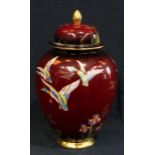 A Carlton Ware rouge royale lustre vase and cover, decorated with ducks and irises, 28cm high