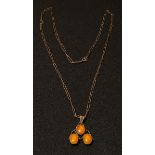 An Arts and Crafts silver pendant set with three cabachons, possibly amber, suspended on chain