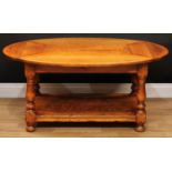 An oak coffee table, possibly Titchmarsh & Goodwin, oval top with fall leaves, turned supports,