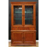 A contemporary Thomasville library bookcase or display cabinet, outswept cornice above a pair of