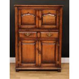 An oak side cabinet, possibly Titchmarsh & Goodwin, rectangular top above a pair of pointed-arch