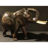 An African ebonised wooden model of an elephant, 43cm high, 60cm wide