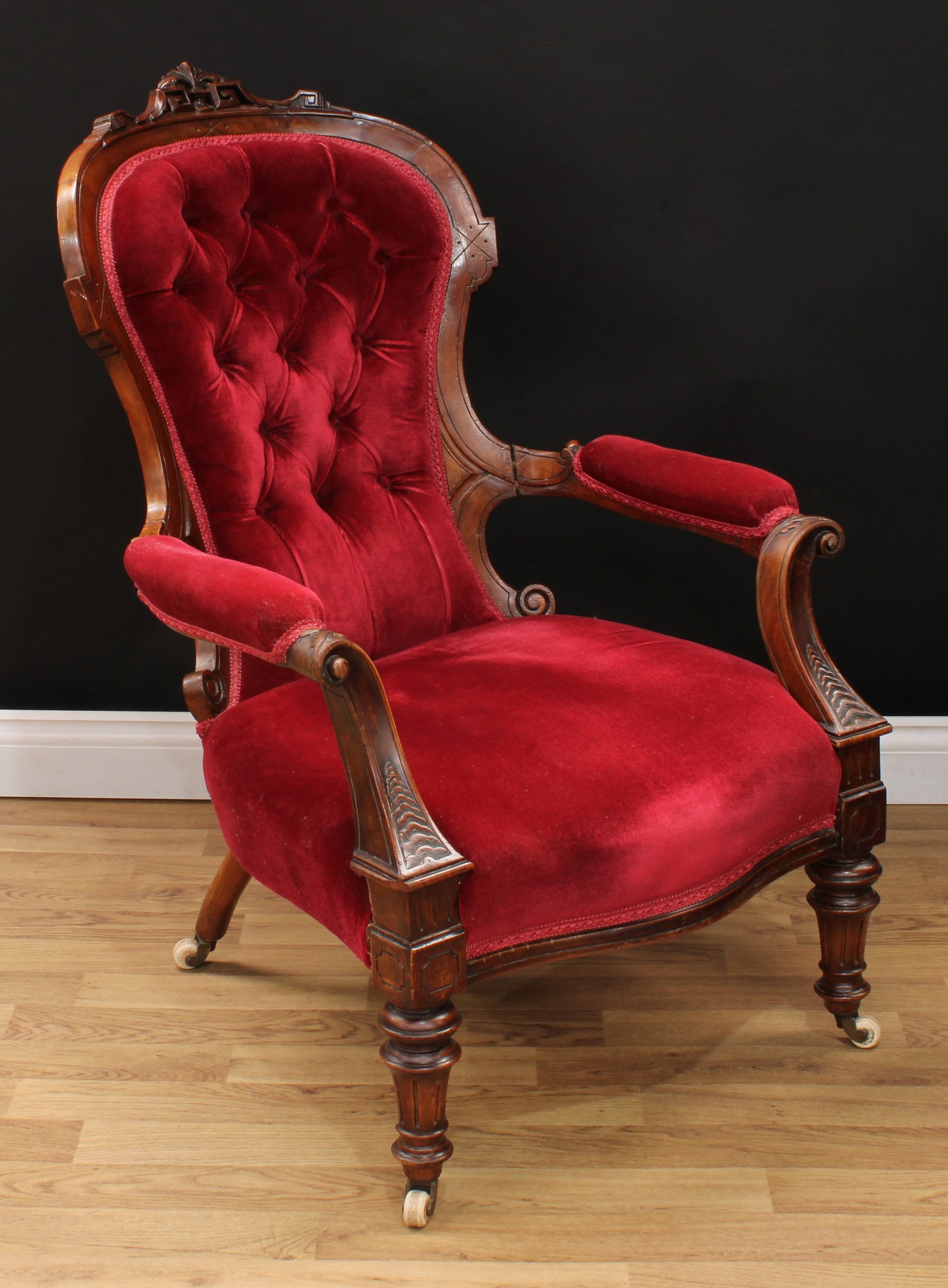 A Victorian walnut drawing room open armchair, curved cresting carved and applied with Greek key