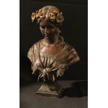 An Art Nouveau style chalk bust of a beauty with garlands in her hair, painted to appear bronze,