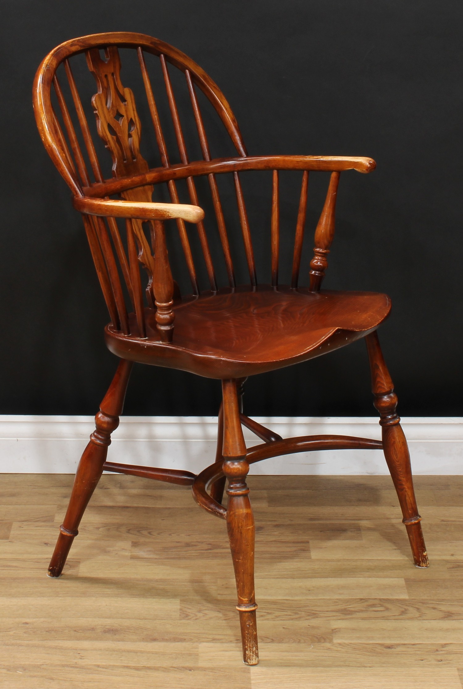 A country house elm Windsor elbow chair, hoop back, shaped and pierced splat, bowed mid-rail, turned