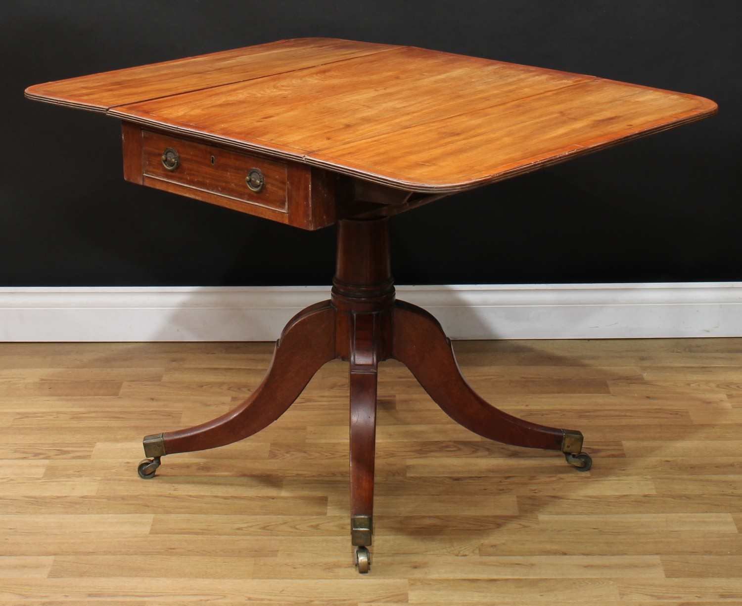 A Regency mahogany Pembroke table, rounded rectangular top with fall leaves above a frieze drawer,