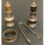 A pair of silver pepper and salts; silver napkin ring; sugar bows