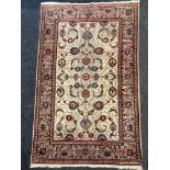 A Persian hand-woven Kashan rug decorated with stylized flora and swags in tones of blue, red and