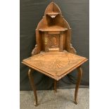 A 17th century style oak credence corner display unit, carved throughout, 134cm high