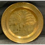A large brass circular tray, embossed with two elephants and palm tree, 90cm diam