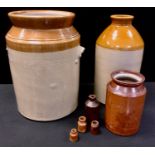 A large 19th century salt glazed stoneware storage jar; a flagon; treacle glazed bottles etc.