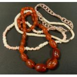 An amber coloured graduated bead single strand necklace; a coral necklace; etc