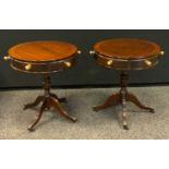 A pair of reproduction drum tables, circular tops, brass handles, turned columns, paw feet, 59cm