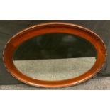 An early 20th century mahogany oval mirror, 84cm wide, c.1920