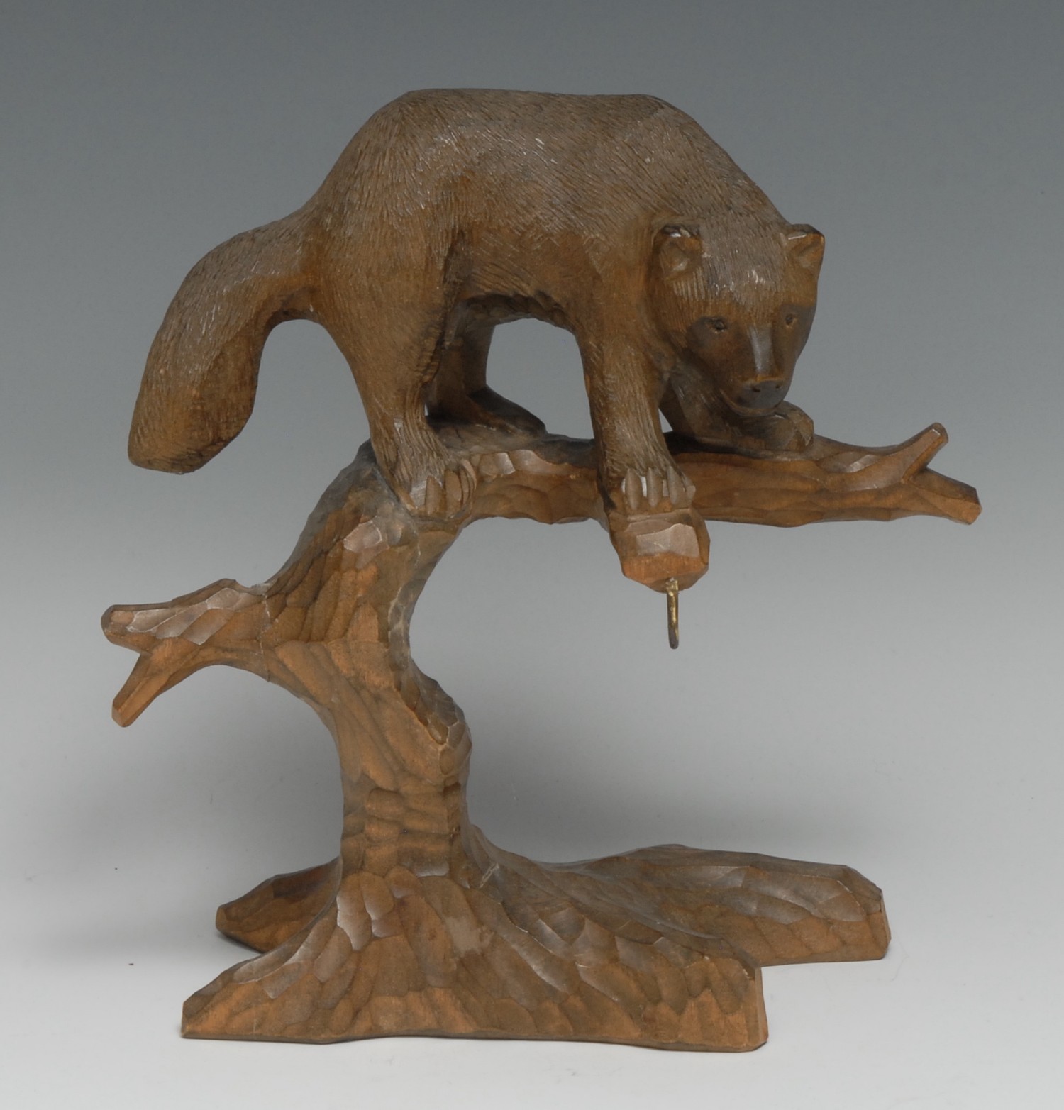 A Black Forest novelty pocket watch stand, carved as a bear upon the branches of a tree, 19cm high