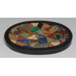 A pietra dura oval desk weight, inlaid with an irregular field of lapis lazuli, malachite and