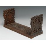 A Burmese hardwood book stand, folding ends pierced and profusely carved with fruiting foliage, 41cm