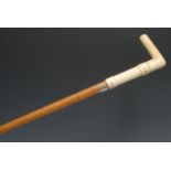 A 19th century gentleman's novelty walking stick, the L-shaped ivory handle carved with faux