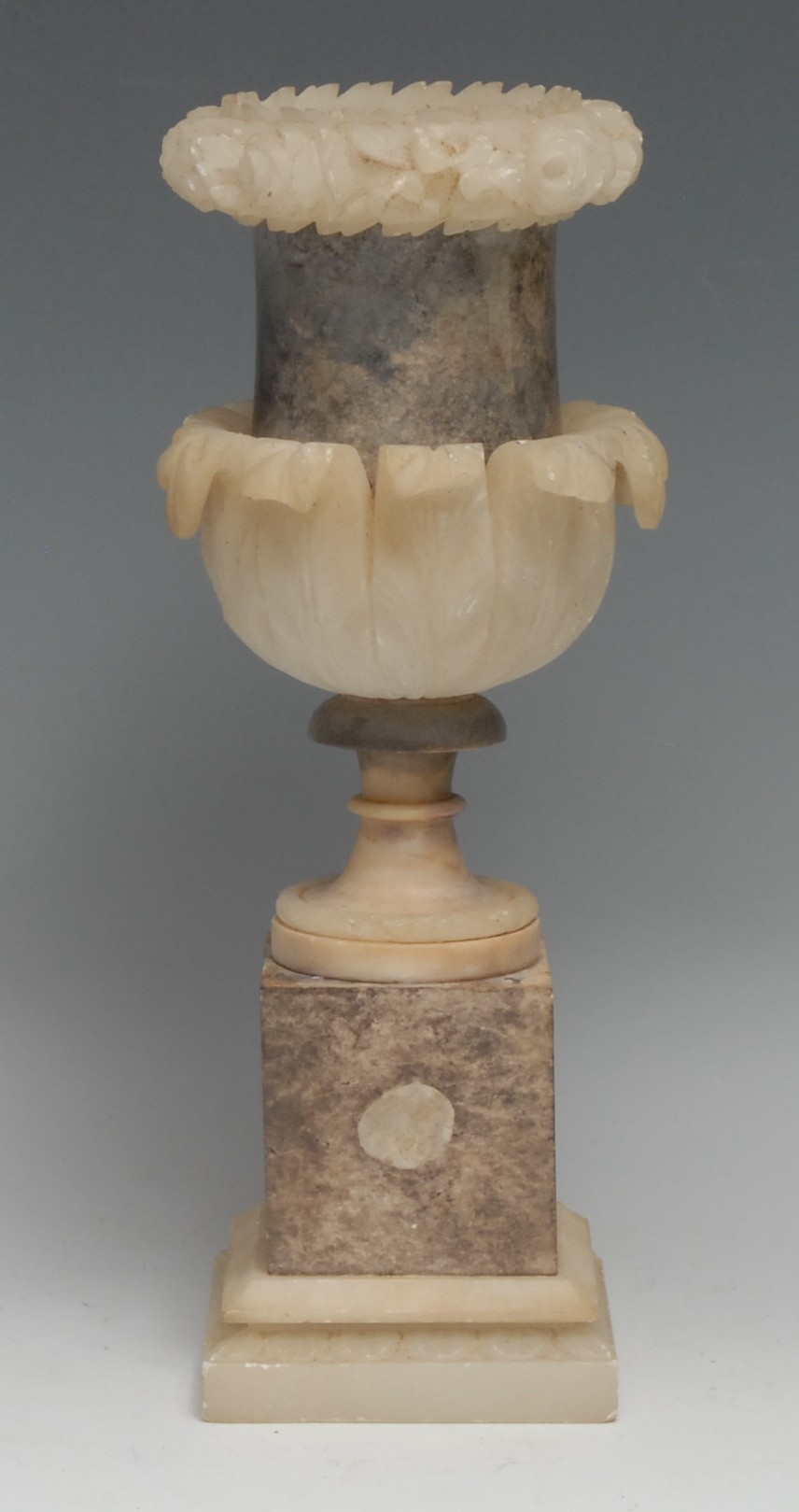 A 19th century alabaster campana mantel urn, carved and applied with bands of flowers and