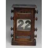 An early 20th century mahogany perpetual desk calendar, oversailing top above glazed apertures for