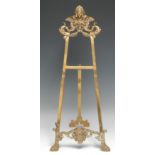 A Baroque design brass table easel, cast with masks and scrolls, 55cm high