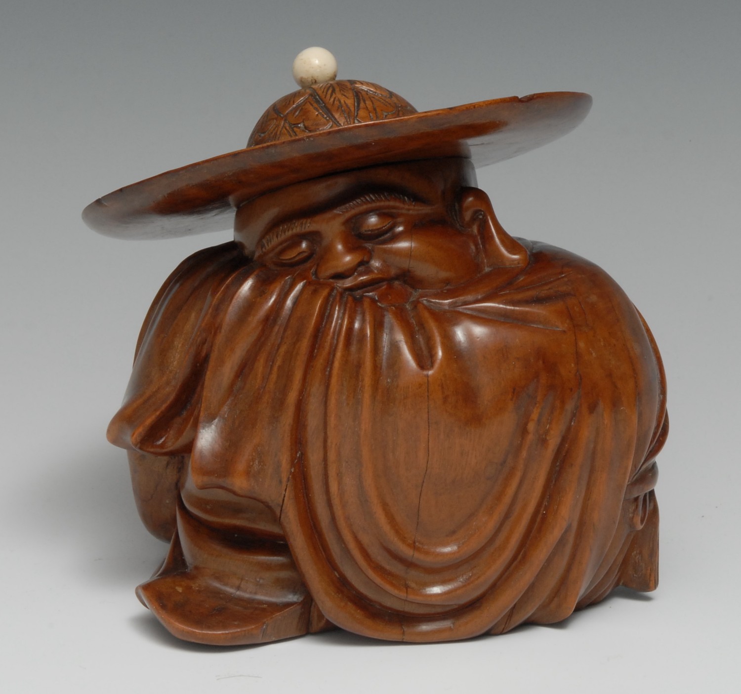 A Chinese hardwood carving, of Hotai, sleeping beneath a broad-brimmed hat, 16cm high, c. 1900