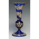 A 19th century Bohemian blue glass trumpet-shaped table vase, decorated in opaque enamel picked
