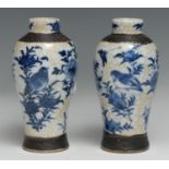 A pair of Chinese baluster vases, painted with flowers, birds and winged insects in underglaze