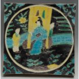 A Chinese tile, decorated in relief with a lady of the court and her attendants, glazed in tones