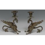 A pair of 19th century candlesticks, each cast as a wyvern, campana sconces, glass eyes, 17cm