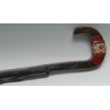 A North African walking stick, the shaft carved in relief with snakes, the curved handle addorned