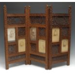 An Indian hardwood three-fold screen, each panel pierced with lotus and trellis, and with