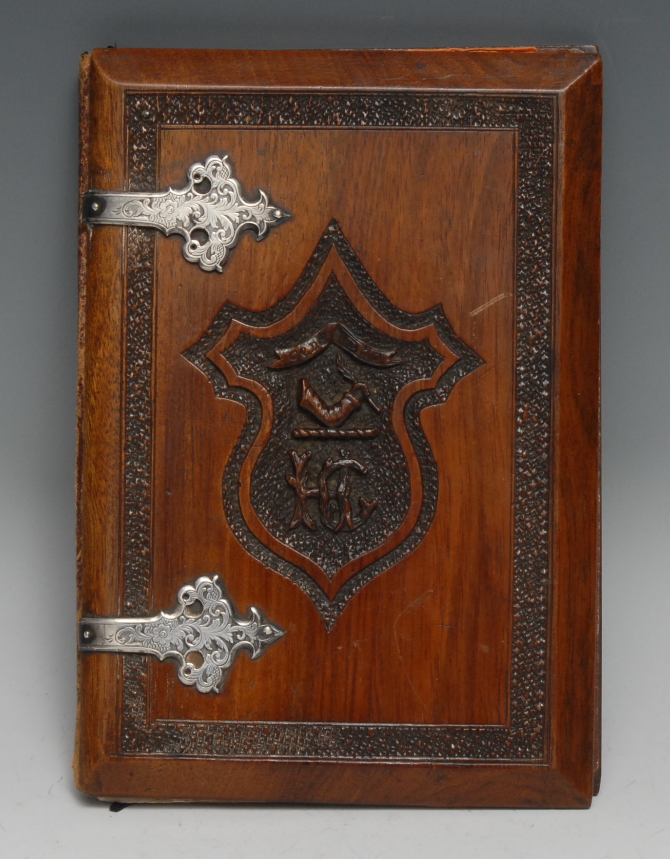 A 19th century Anglo-Indian silver coloured metal mounted hardwood blotter or album, carved to recto