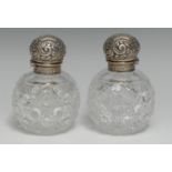 A pair of Edwardian silver mounted hobnail-cut globular scent bottles, each hinged cover embossed