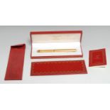 A Must de Cartier gold-plated ball point pen, numbered 580244, 14cm long, suede sleeve, cased en