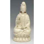 A Chinese Blanc de Chine figure, of Guanyin, seated in a lotus, glazed in an ivory tone, 26cm