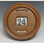 An early 20th century oak circular wall hanging perpetual calendar, glazed apertures for day, date