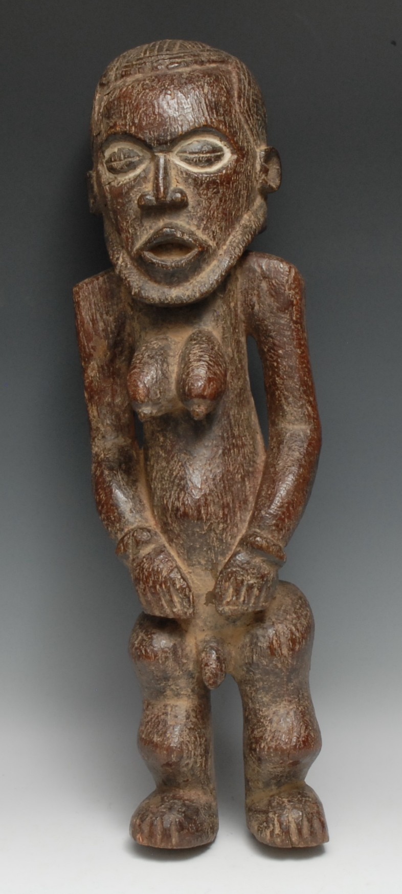 Tribal Art - an African figure, hermaphroditic physiology, the eyes picked out with white pigment,