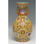 A Chinese ovoid reticulated puzzle vase, painted in polychrome enamels with flowers on a yellow
