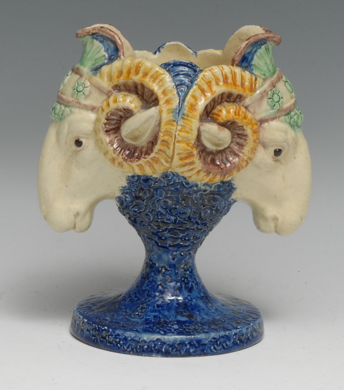 A 19th century Renaissance Revival majolica vase, boldly modelled with twin ram masks, glazed in the