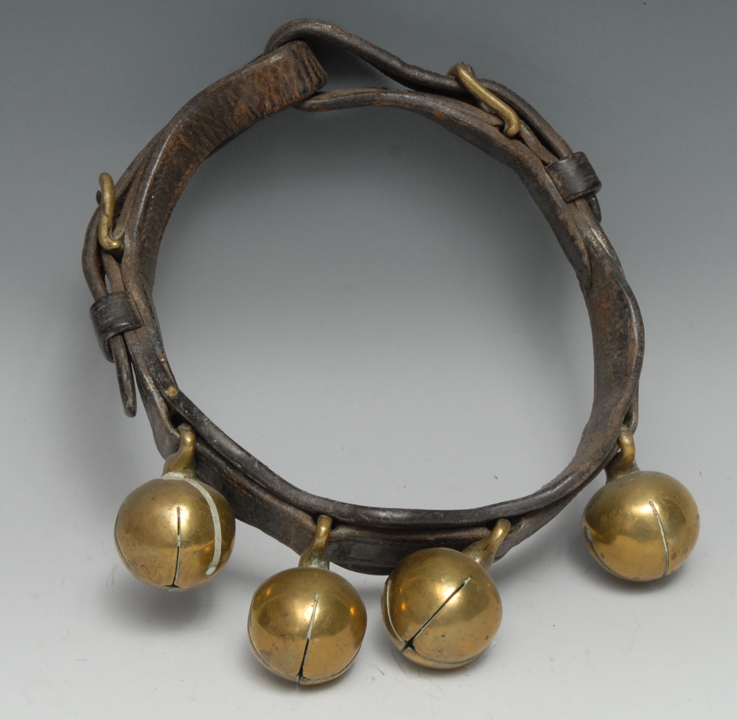 A 19th century leather animal collar, with four crotal bells, 20cm diam