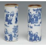 A pair of Chinese cylindrical vases or brush pots, decorated in tones of underglaze blue with The