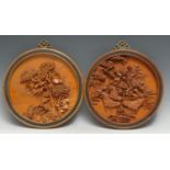 A pair of Chinese sandalwood circular plaques, carved in relief with chysanthemums, and with